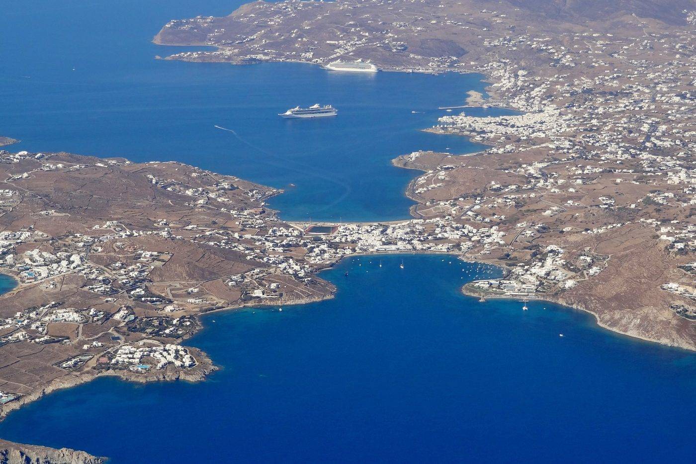 Aerial view of the south-west of Mykonos, with the deep blue bay of Ornos