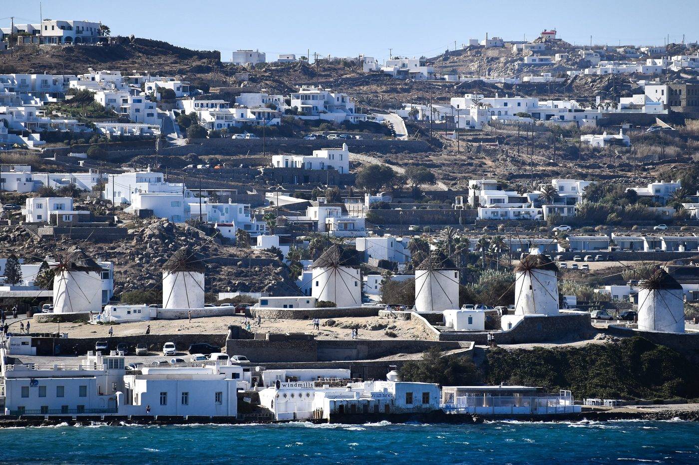 The row of Kato Mili windmills above the sea, with the white houses of Mykonos Town on the hill behind