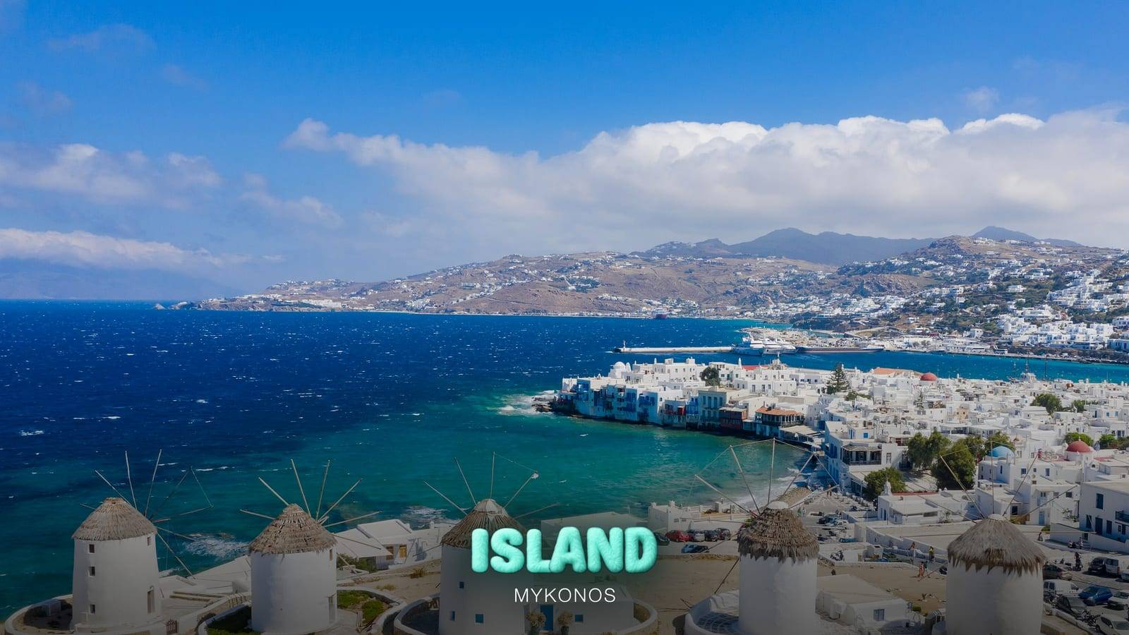 The Kato Mili windmills, Little Venice and Mykonos Town on a sunny summer day, with the Party Island Mykonos logo